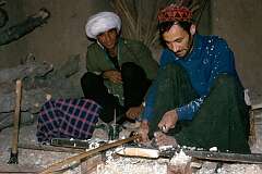 In a workshop in Herat a man uses a hand-operated lathe. By moving the bow back and forth, he turns the wooden rod and makes a groove with a chisel.