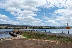 View of the dam, with Ellendale Road, damming the Derwent River (at right), forming Meadowbank Lake (at left).