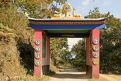 The gate to Thembang village with its Buddhist symbols: the deer and wheel, representing the Buddha’s first teaching after his awakening when he “turned the wheel of the Dharma” at Deer Park near Sarnath, India.