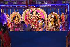 Durga, the multi-armed goddess and other Hindu deities, on the stage in a temporary temple in a street, for the Navaratri Festival.