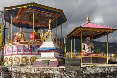 A pavilion with images depicting life of the Buddha, statues and a chorten (stupa), at the complex with the giant Buddha statue.