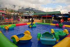 Children in paddle boats on the fairground of Tawang.