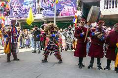 Masked dancers, with drum and cymbal, in the Carnival Parade on the first day of the Tawang Festival.