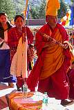 A monk precedes women carrying “khata” ceremonial shawls on the terrace of the monastery at the start of the third day of the Drub-chod-Chen-Mo Cum Bomdila Torgya.