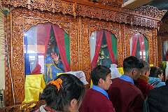 The three images of the protecting gods, in niches behind curtains that are now partly opened.