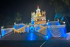 The 1609 Immaculate Conception Church, a Baroque-style Catholic church with a grand façade atop a small hill, illuminated at night.