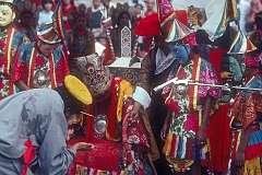 A scene with a throne and masked performers in the Lhamo (Tibetan Opera).
