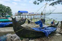 Fishing canoes and a Chinese fishing net (Cheena vala in India), stationary lift net, fixed land installations for fishing along the Beach Walkway on the shore in Kochi (Cochin).