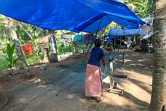 Spinning the wheel to twist the coconut fibres, making coir ropes from coconut fibres on Munroe Island.