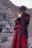 A young monk blowing a conch shell to announce the start of a “puja”, religious ceremony in Hemis Gompa.
