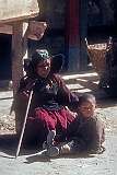 A grandmother with her traditional headdress and her grandson, watching the ceremony at the monastery.