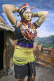 Portrayal of a young, rich Sümi woman posing in her fineries: the extra rows of beads in her girdle symbolises her rich status in society. The Sümi Naga primarily inhabit the central and southern regions of Nagaland.