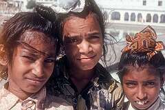 Three young Sikh boys wearing a "rumal", covering their hair as a sign of respect in the temple. Sikhs don't cut their hair and it is tied in a knot (joora or rishi).