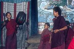 Young lamas, Buddhist boy monks, beating a drum.