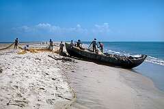 Fishermen on the beach in Dhanushkodi; in the background what was called Adam's Bridge, a chain of  limestone shoals between Pamban Island and Mannar Island, off Sri Lanka.