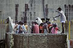 Men and women bathing at one of the 22 Tīrtha (theertam, wells) in the Ramanathaswamy Temple. It is a significant ritual for pilgrims,: the water is believed to have healing and purifying properties.