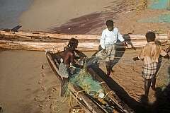 Fishermen with their canoe and net on the beach in Kanniyakumari.