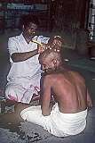 A man in Palani has his head shaved as devotion to Shiva, symbolising the surrender of ego, pride, and worldly vanity.