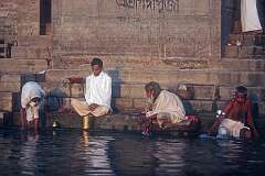 Praying and bathing on the banks of the Ganges, the holy river in Varanasi, in the light of the rising sun.