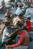 A man and boy getting a haircut on the banks of the Ganges river.