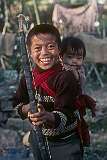 Rinchin Dorjee, a young Bhutanese boy with his bow and arrow and his little brother Rinchin Paden strapped to his back at Jangsa Gompa, a Bhutanese Monastery in Kalimpong.