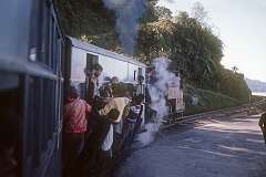The Toy Train, a 2 ft gauge railway, leaving Darjeeling on its way to New Jalpaiguri Junction, Siliguri. Children hitching a ride, hanging from a wagon.