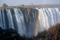 The Main Falls and Rainbow Falls of Victoria Falls, with a rainbow in the afternoon.