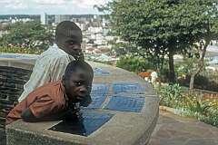 Two boys at the view point on The Kopje, showing distances from there, with panoramic view of Harare, then named Salisbury