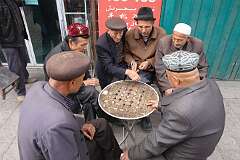 Kuqa, Xinjiang-Uyghur, China, 2011 - Uyghur men playing a board game.